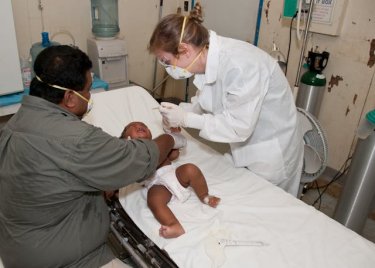 baby lying down on hospital bed getting a checkup