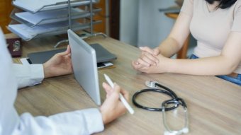 Physician having a conversation with a patient during a medical consultation