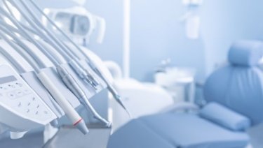 A dental chair with dental equipment in the background