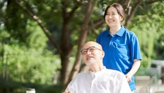 A woman sitting next to an older man, both smiling and engaged in conversation